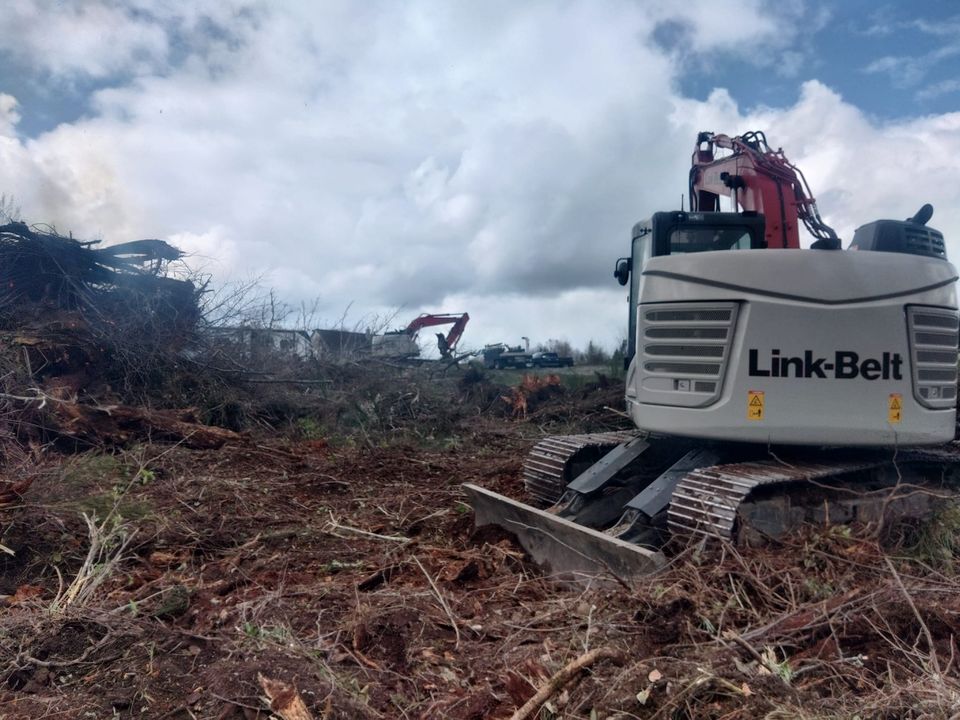 Excavator clearing land